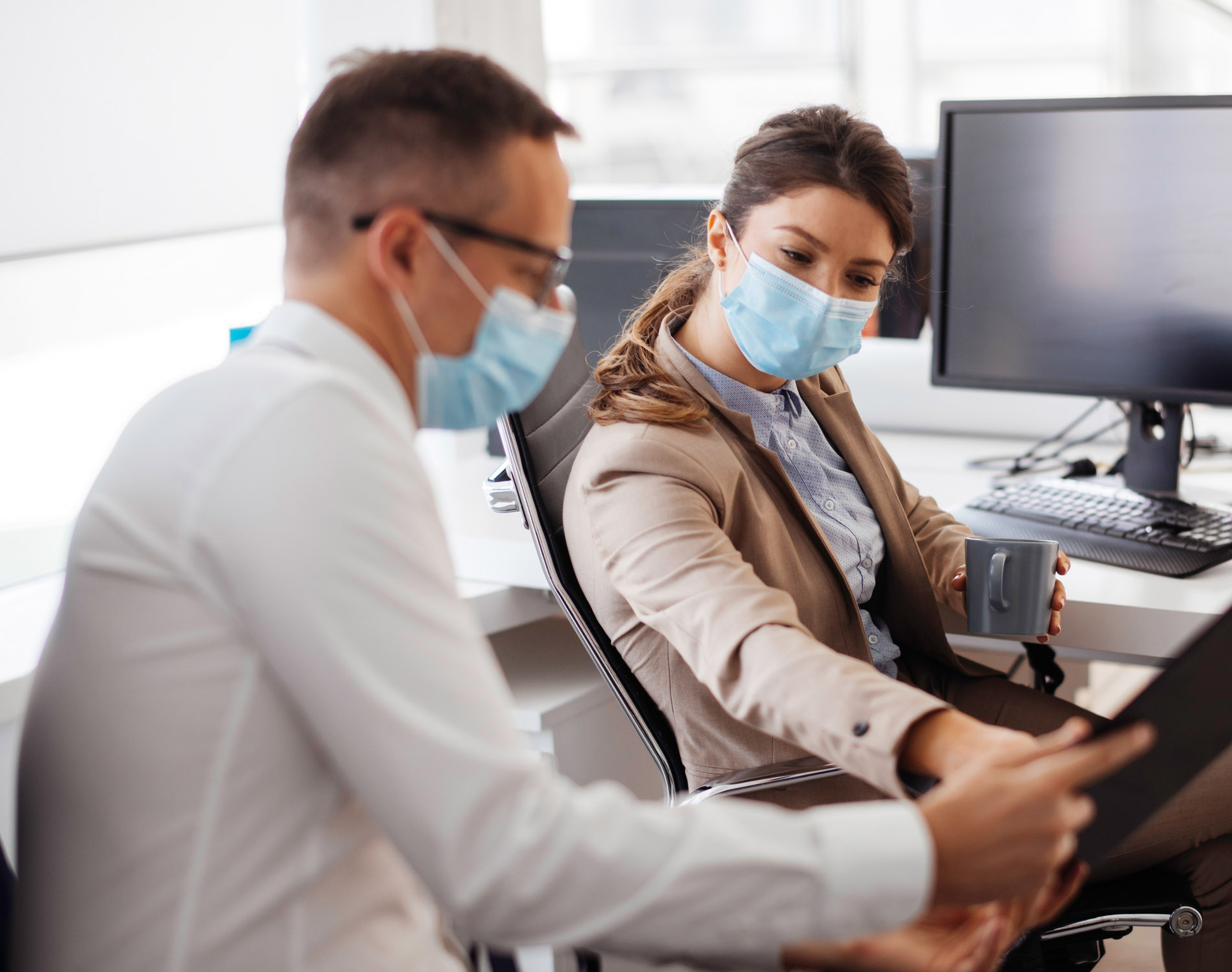 Business colleagues wearing masks in office